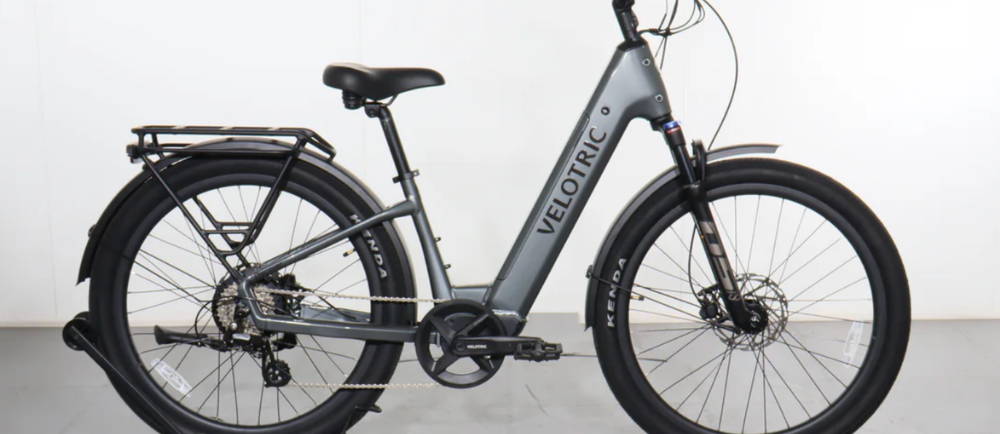 A silver Velotric Discover 2 electric city bike in a city