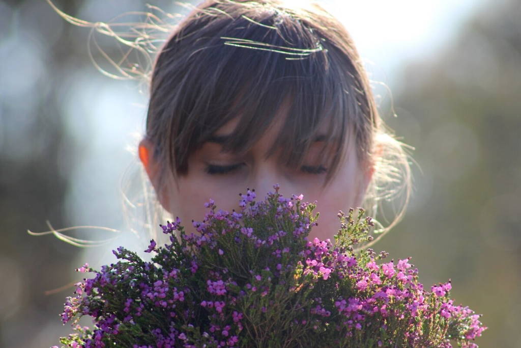 Fille tenant un bouquet et le sentant.