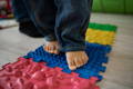 Baby walking on a colorful tactile blocks.