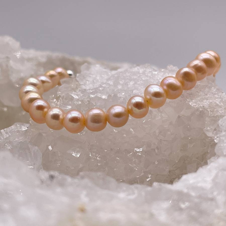 Bracelet en perles d'eau douce sur un amas de quartz cristal de roche