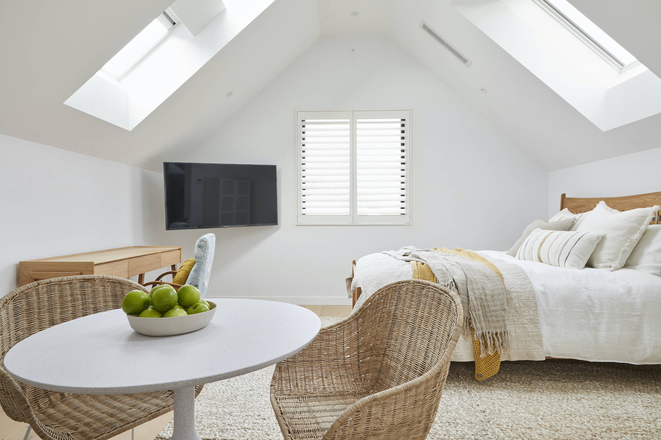 A TV-Mirror hanging on the wall of a coastal, elegant bedroom setting 