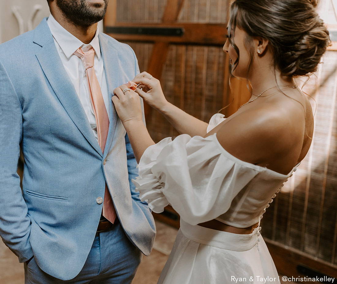 bride helping groom with pocket square