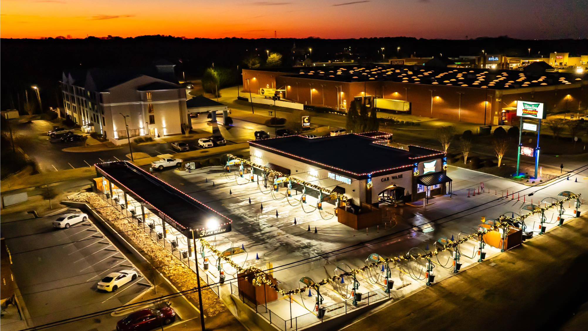 Aerial view of the Carrollton wash at dusk, its neon sign glowing against the sunset