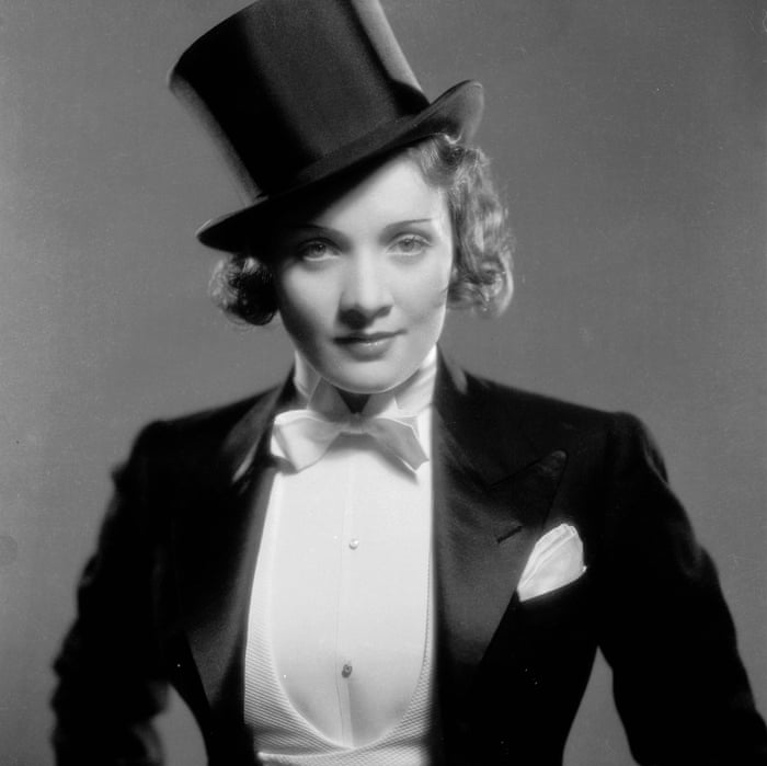 Black and white photograph of Marlene Dietrich wearing gazing into the camera wearing a tuxedo and top hat.