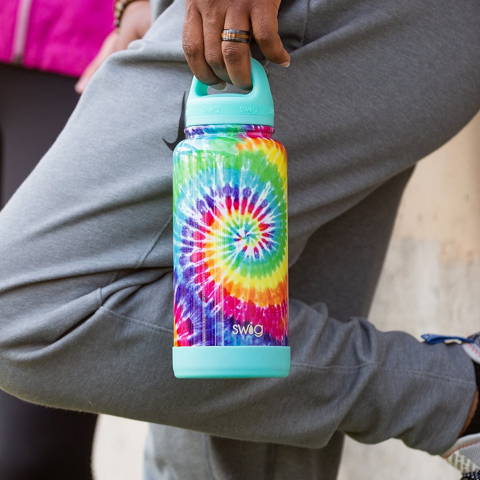 A person holding an extra large tie-die Swig bottle