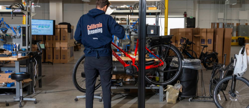 a man inspecting a gazelle electric bike at an upway center