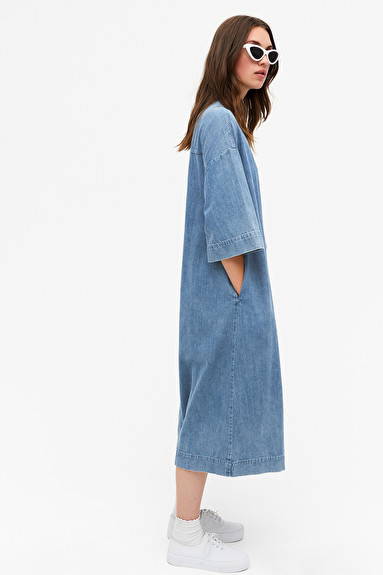 Side shot of woman wearing blue indigo organic cotton denim dress