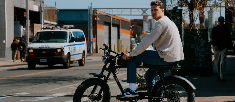 a man in jeans and a white shirt sitting on an e-moto