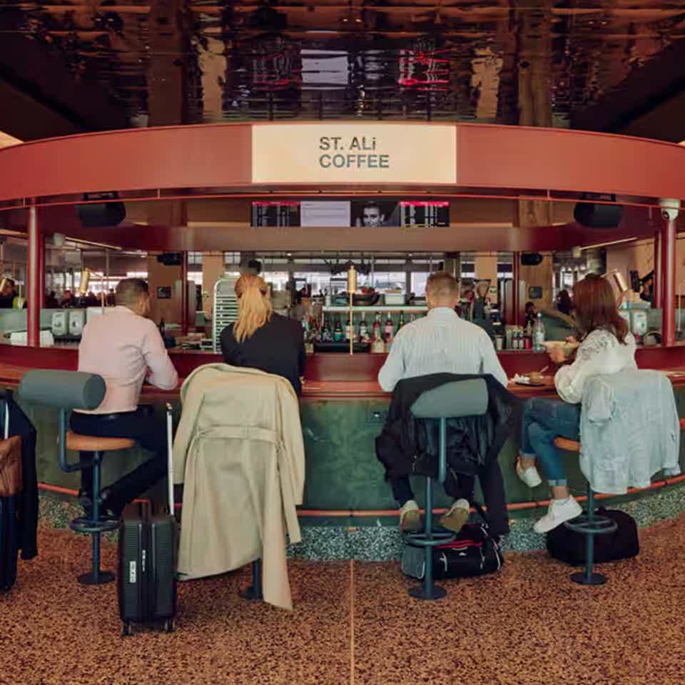 Busy ST. ALi coffee cafe with people having coffee surrounding the bar