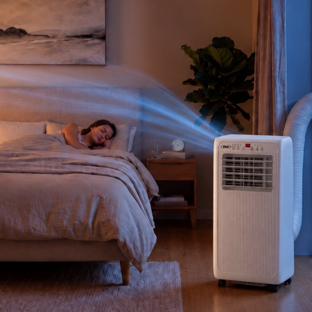 Mujer durmiendo en un dormitorio con el aire acondicionado portátil ANWO AIR-3 funcionando en modo sueño