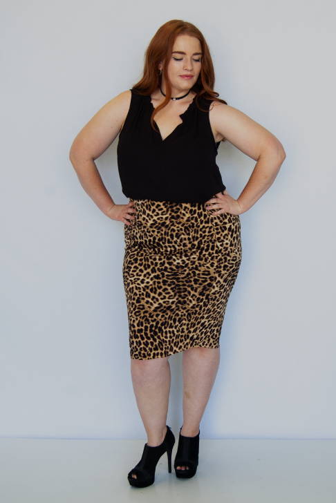 A woman wearing a sleeveless leopard print skirt.
