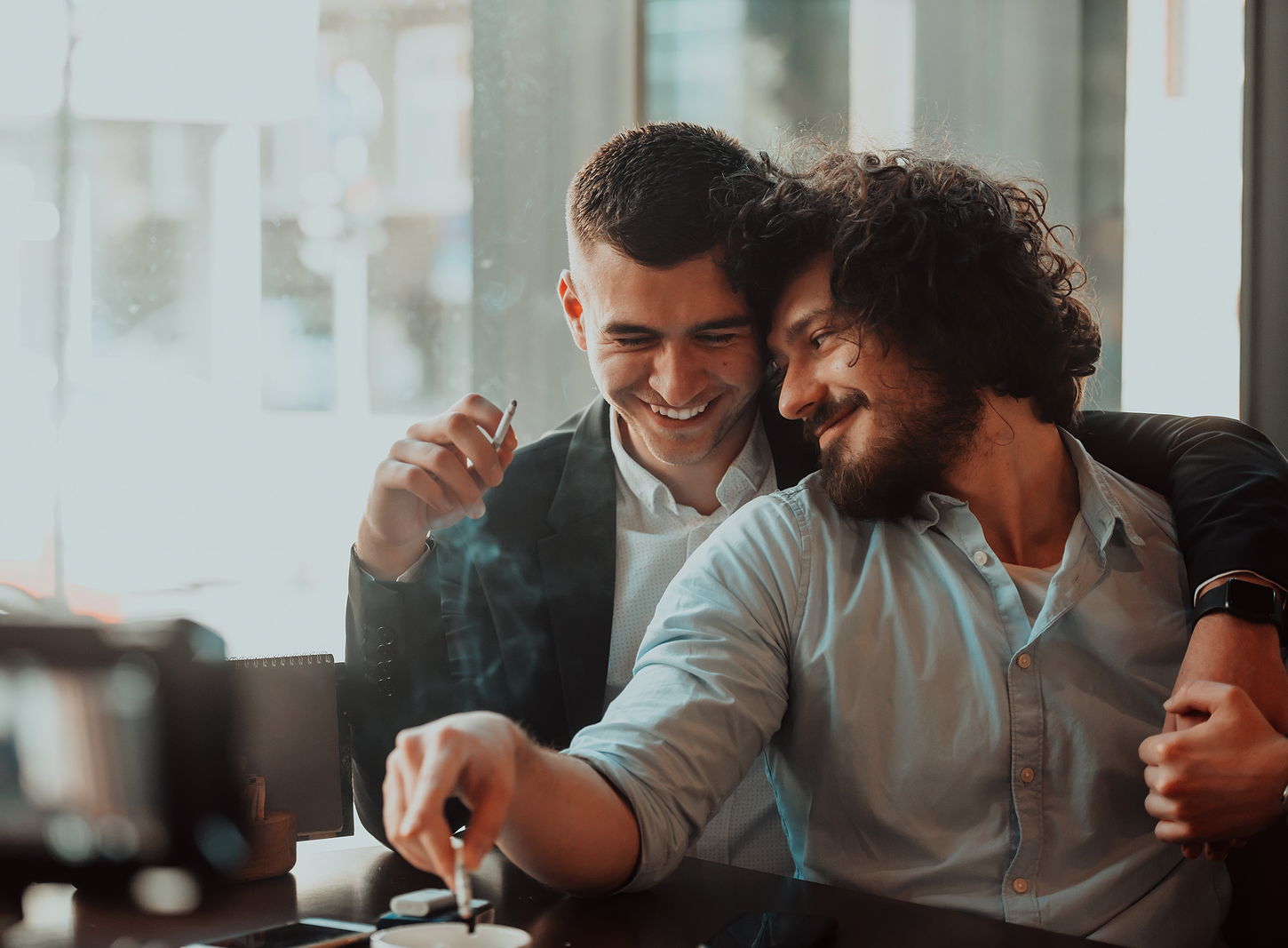 A multi ethnic male couple showing affection in public holding each other.