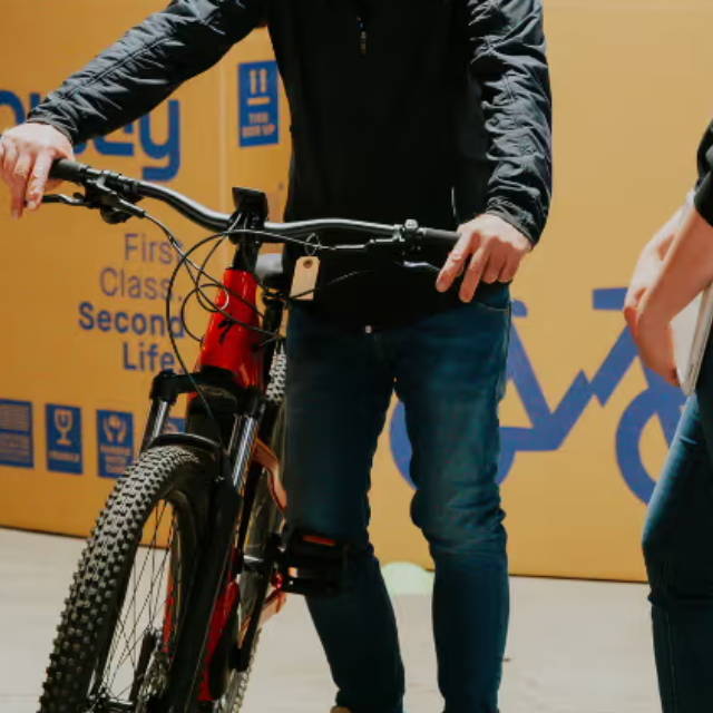 a man standing in front of an upway bike box and gripping the brakes on an electric mountain bike