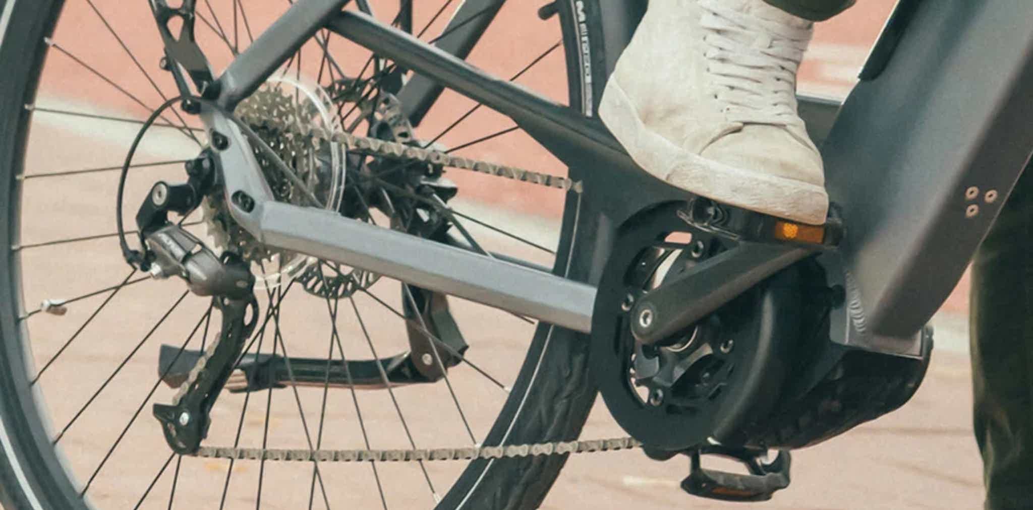 Imagen de recurso de una persona llevando el pie al pedal de su e-bike.