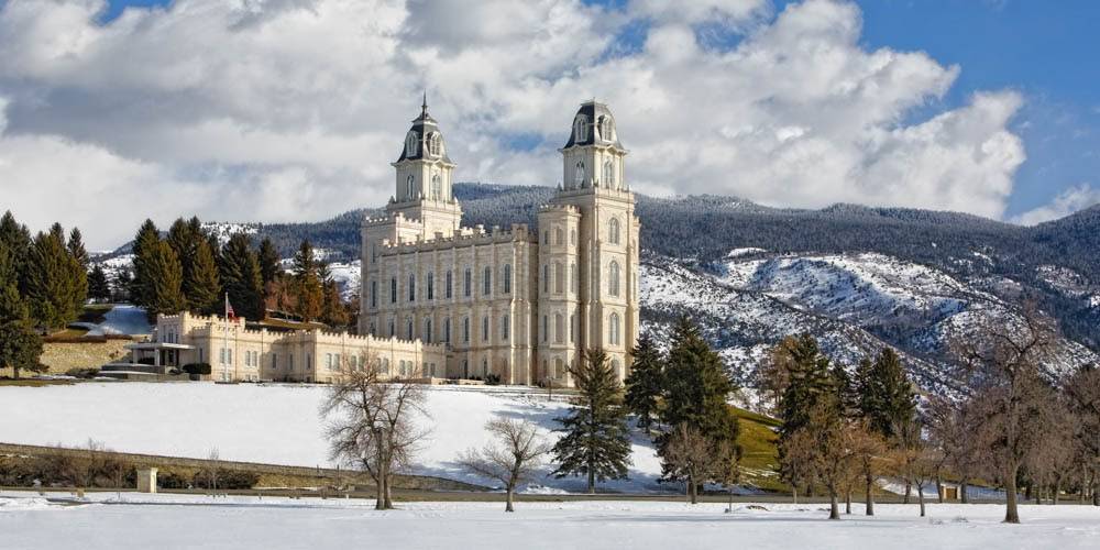 Manti TEmple standing proudly in front of snowy mountains. 