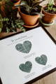 family fingerprint keepsake artwork framed on table next to potted plants