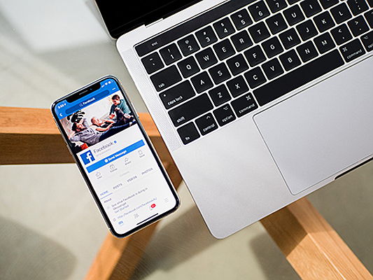  Portim​ão
- Smartphone avec Facebook à côté de l'ordinateur portable du travail.