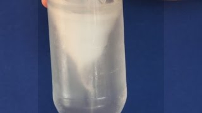 Close up of water swirling in a bottle like a tornado