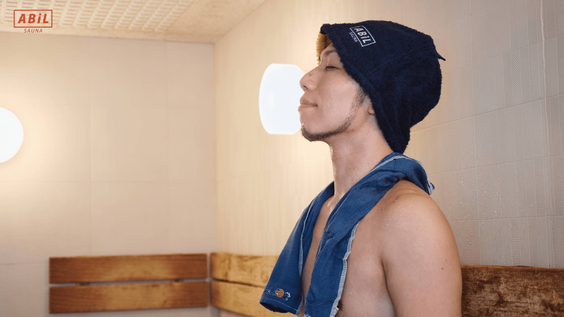 サウナで深呼吸をしながらリラックスする男性。自律神経を整えるサウナの時間。