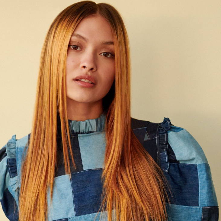 Davines model with blonde short curly hair with bangs