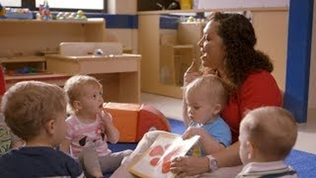 Primrose teacher reads to the toddlers in her class emphasizing her pronunciation