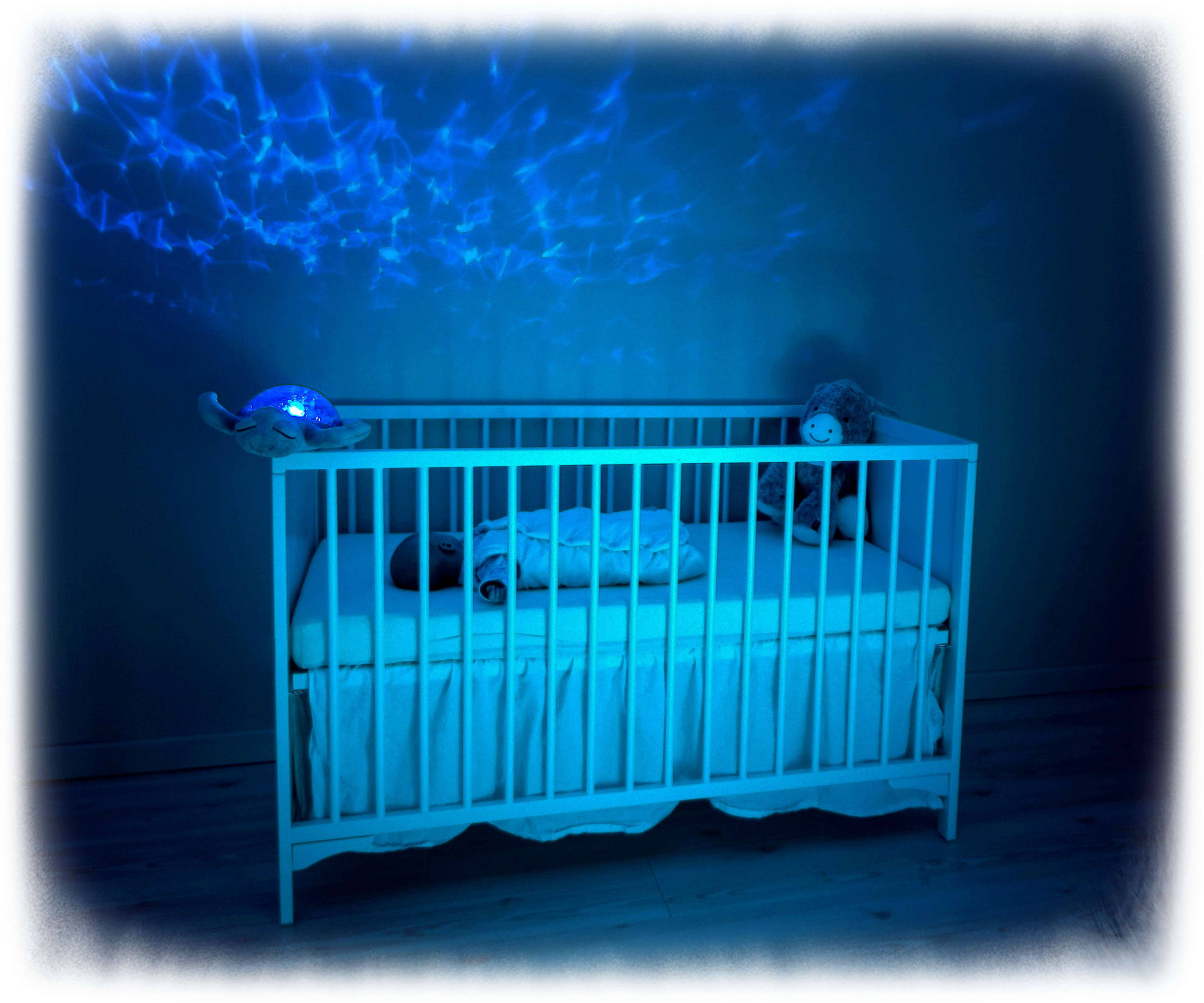 baby with night light shining above cot