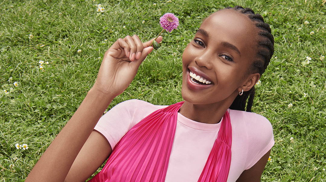 femme joyeuse avec gloss brillant et huile à lèvres rose 