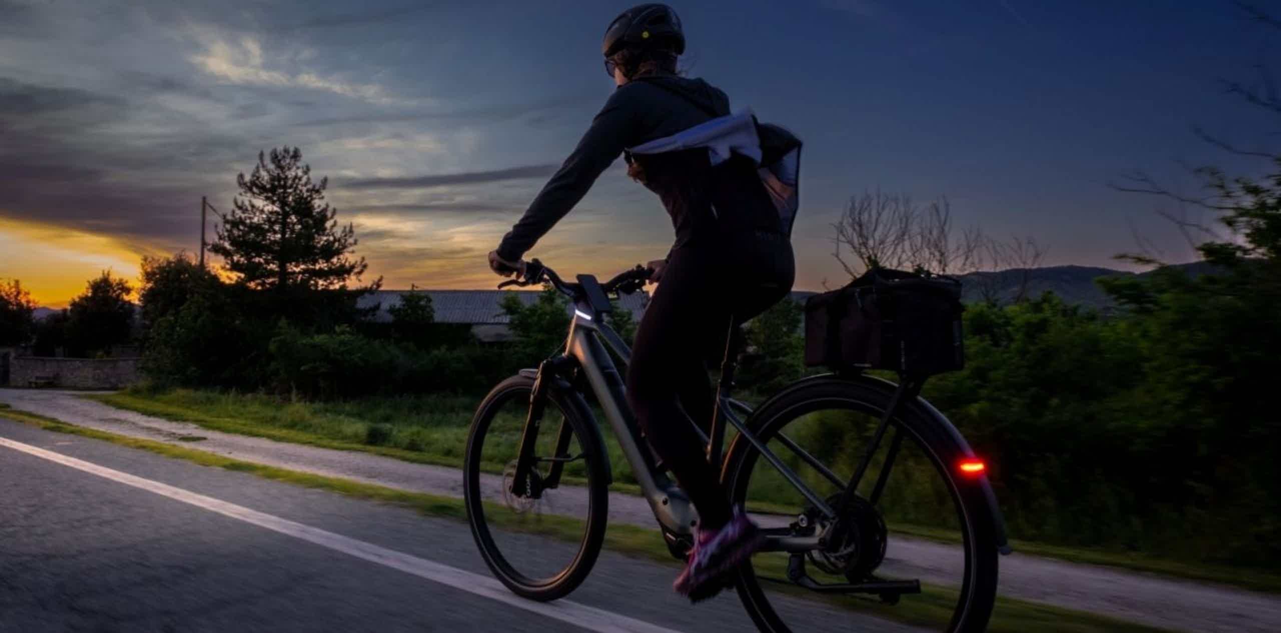 Imagen de recurso de una persona circulando con una e-bike con su luz trasera y delantera.