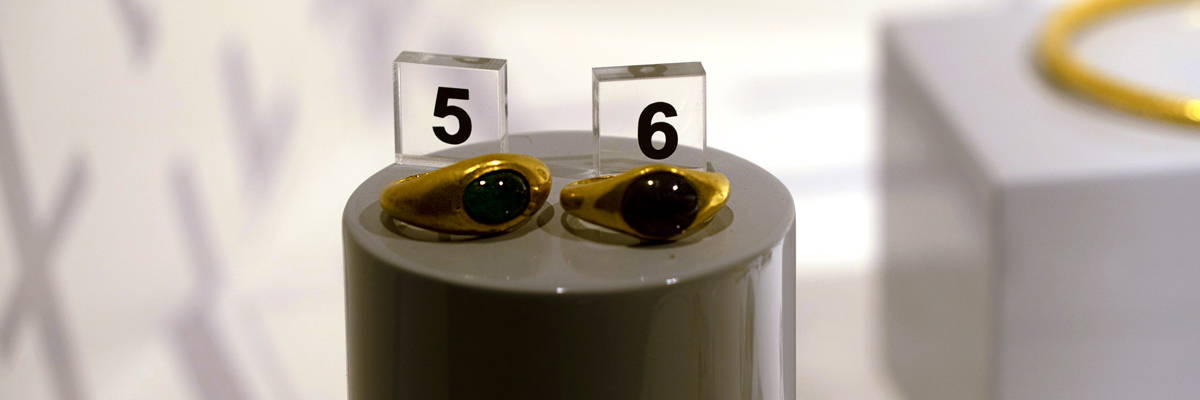Two gold rings with stone from ancient Rome on a museum display at the ruins of Ercolano Herculaneum in Italy.