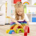 Little girl arranging the Montessori Rainbow pieces on the floor. 