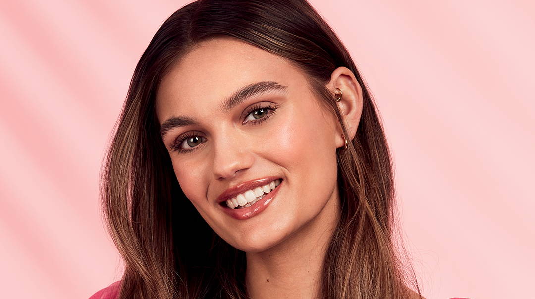 femme souriante portant un gloss hydratant effet brillant