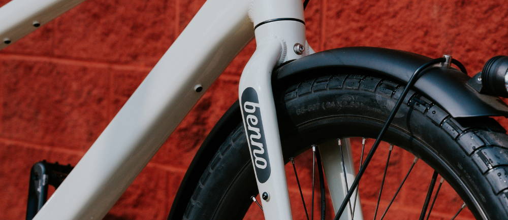 a benno boost electric cargo bike in front of a red wall