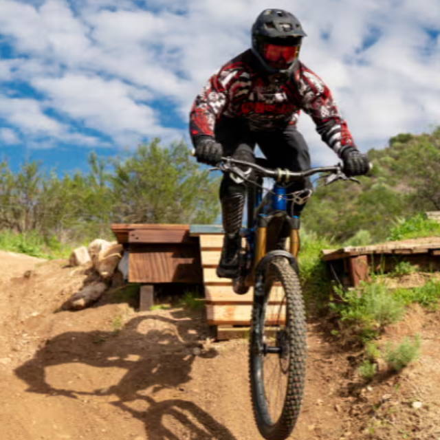 a person launching off a jump on a full suspension electric mountain bike