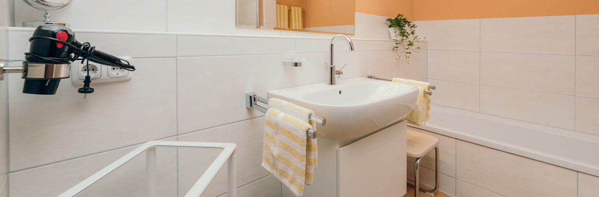 Badezimmer mit Badewanne und Haartrockner.