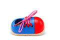 Red-blue wooden shoe with pink shoelace.