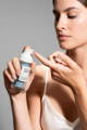 woman applying anti-aging serum on her face