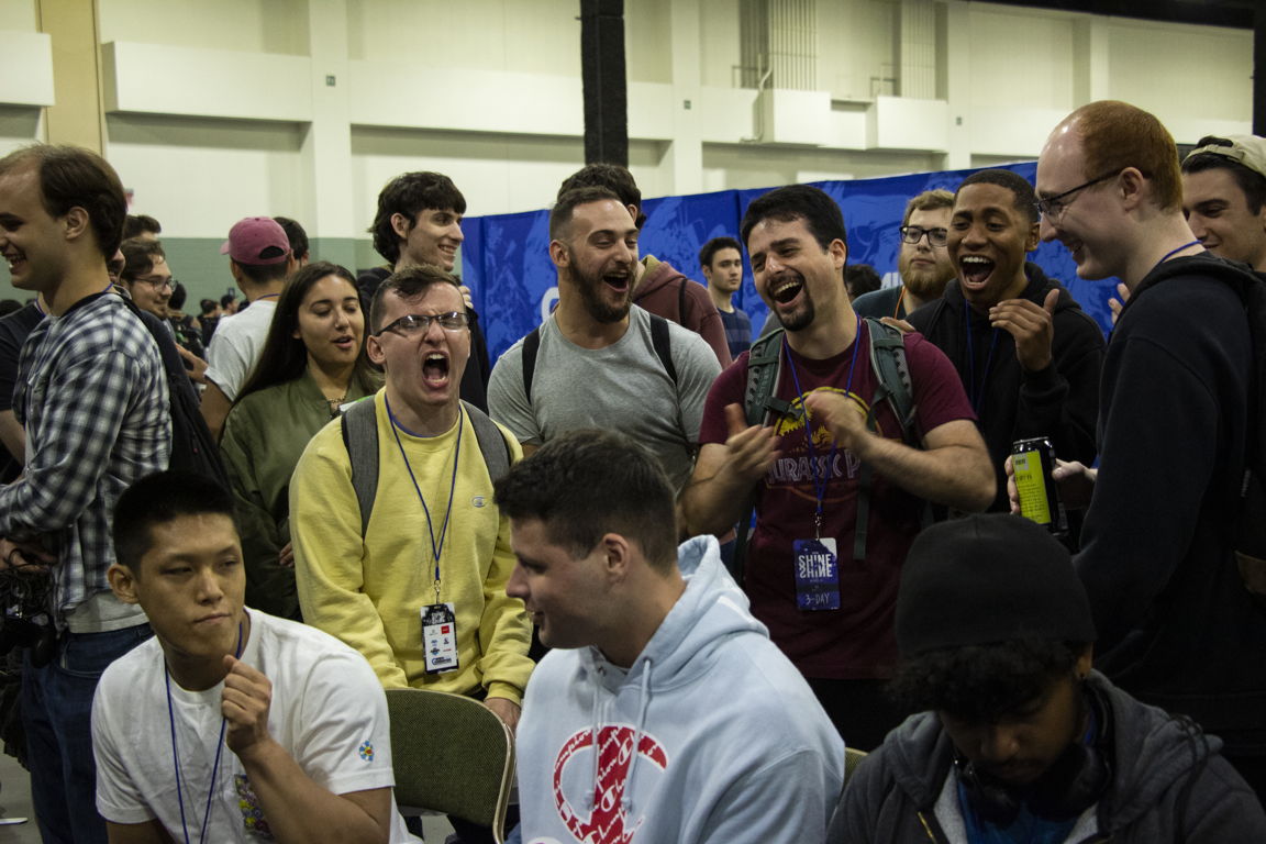 Crowd of passionate competitors enthusiastically cheering for their friend in his tournament match