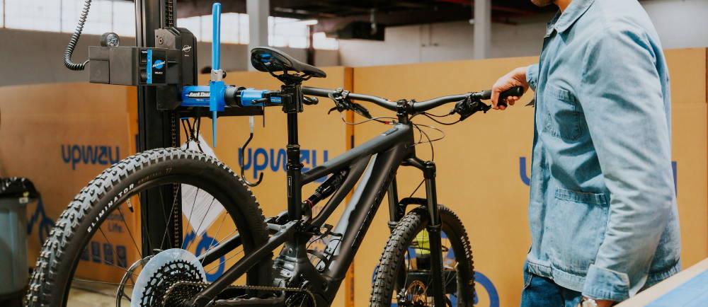 Man next to Specialized Levo electric bike on repair stand