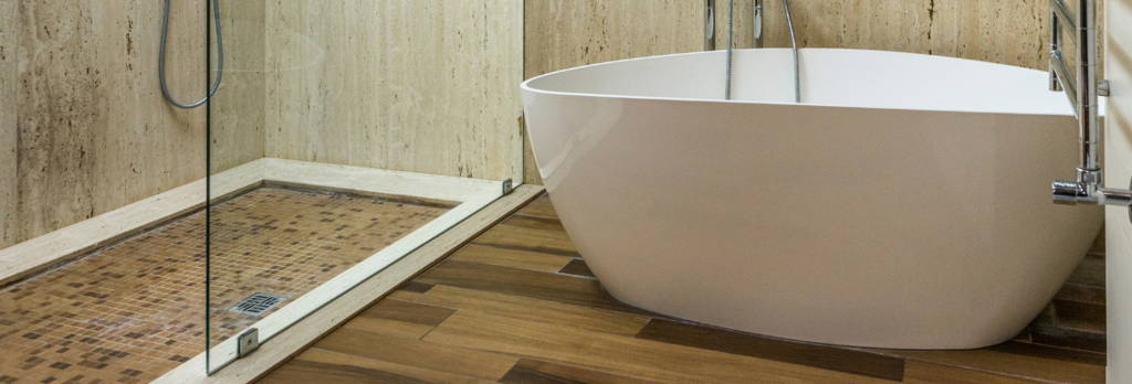 Badezimmer mit Badewanne, Holzboden, Fliesen und Glasflächen