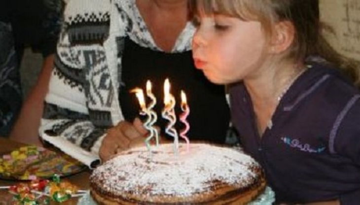 kind pustet kerzen aus