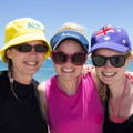 Three ladies on the beach wearing Australia themed caps. 