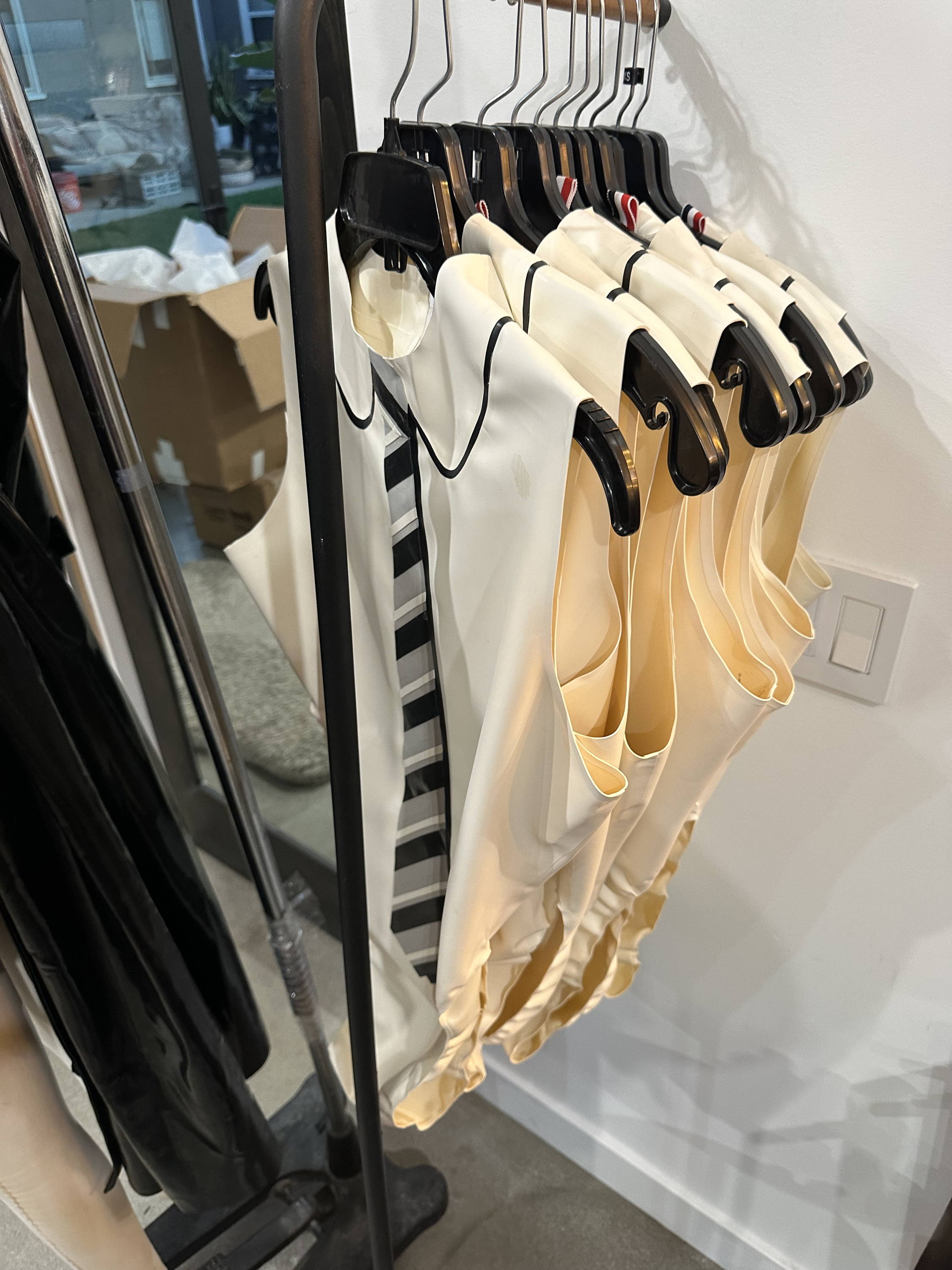 Rack of ivory latex vests designed by Vex Clothing for Thom Browne runway collaboration