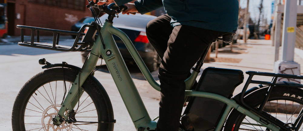 a man riding a green Momentum PakYak E+ electric long tail electric cargo bike