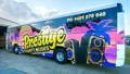 Outside view of the Prestige Party Bus. Vibrant livery decals on the side.