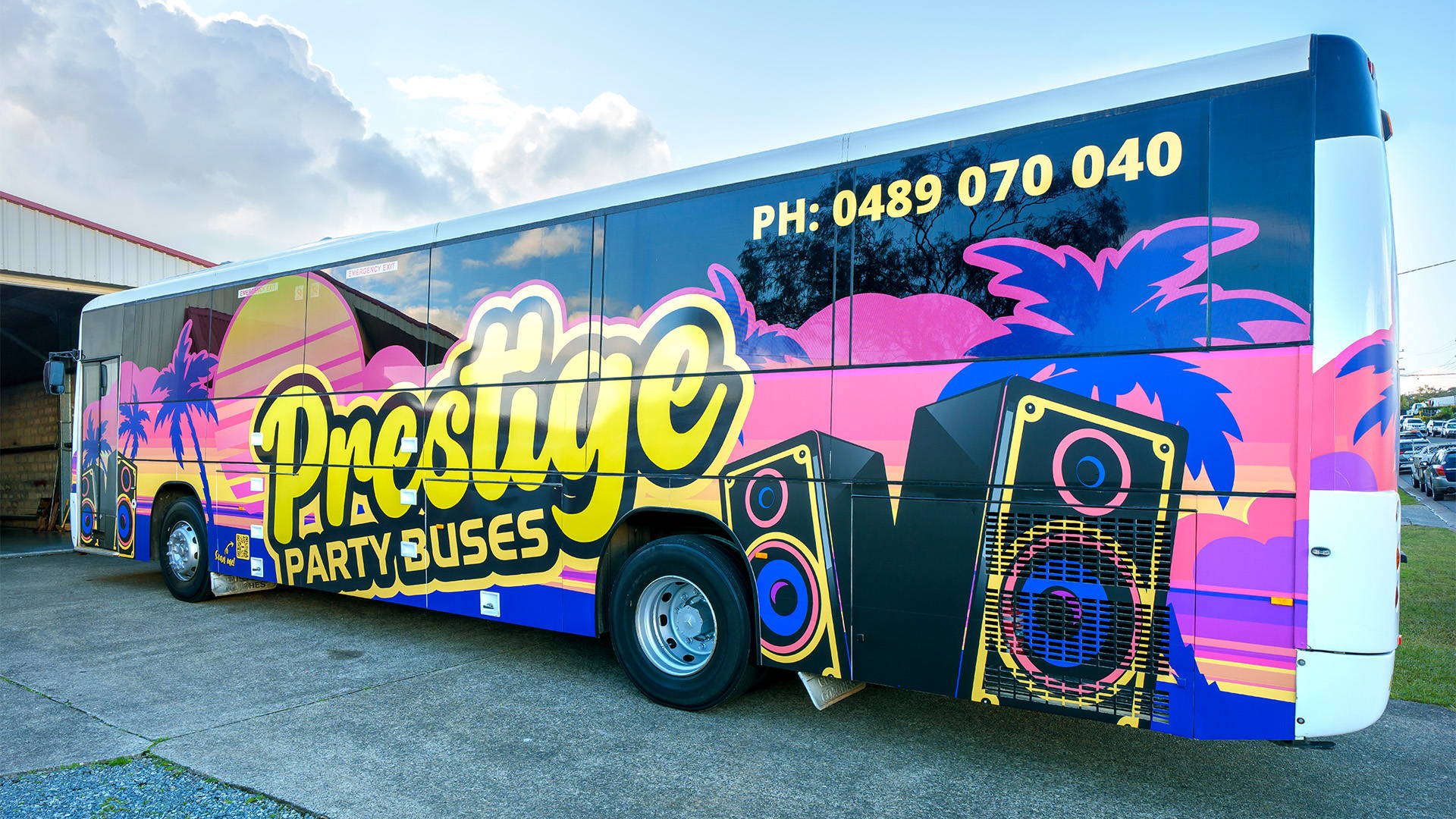 Outside view of the Prestige Party Bus. Vibrant livery decals on the side.