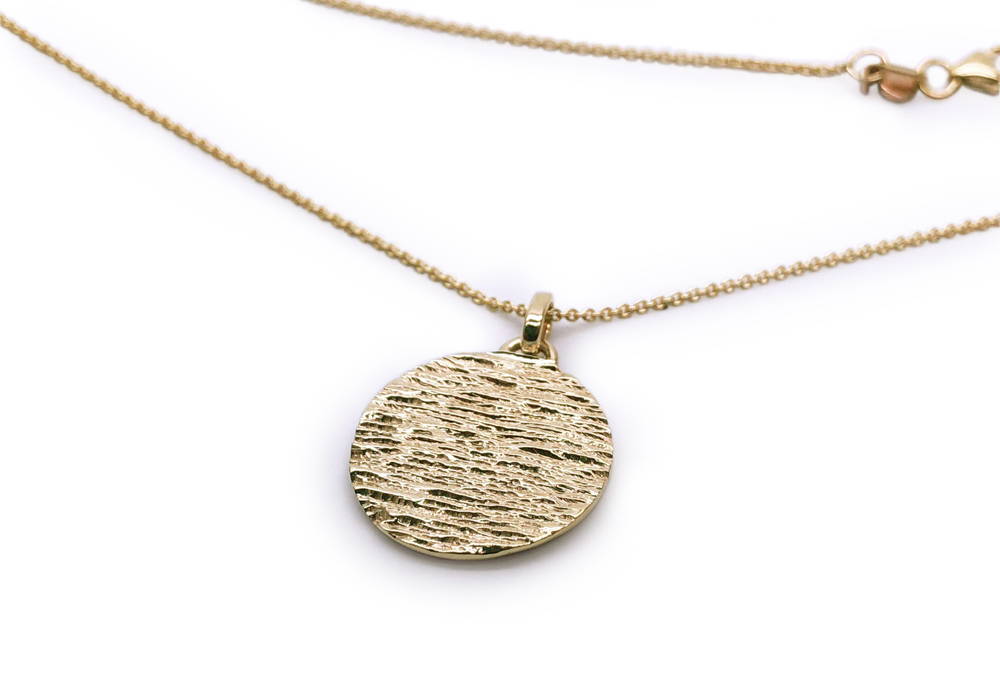 Pendant with textured medallion in yellow gold
