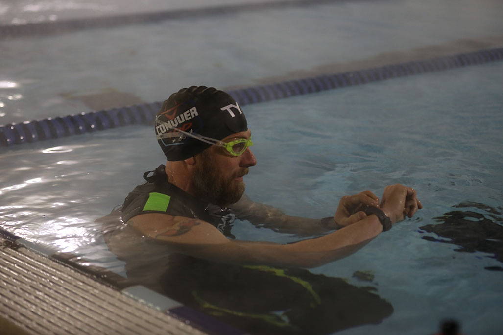 James Lawrence looking at watch in pool