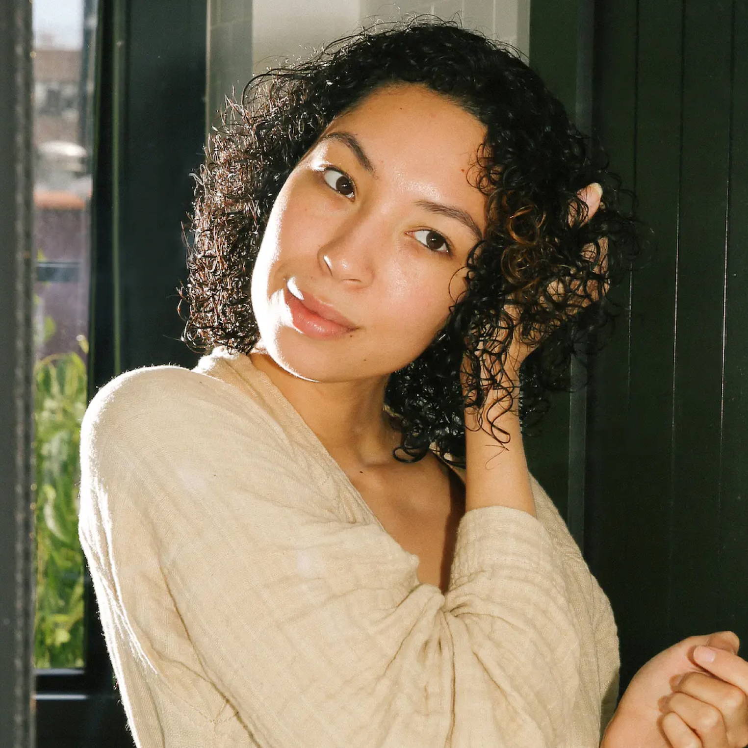 Davines model scrunching her curly hair