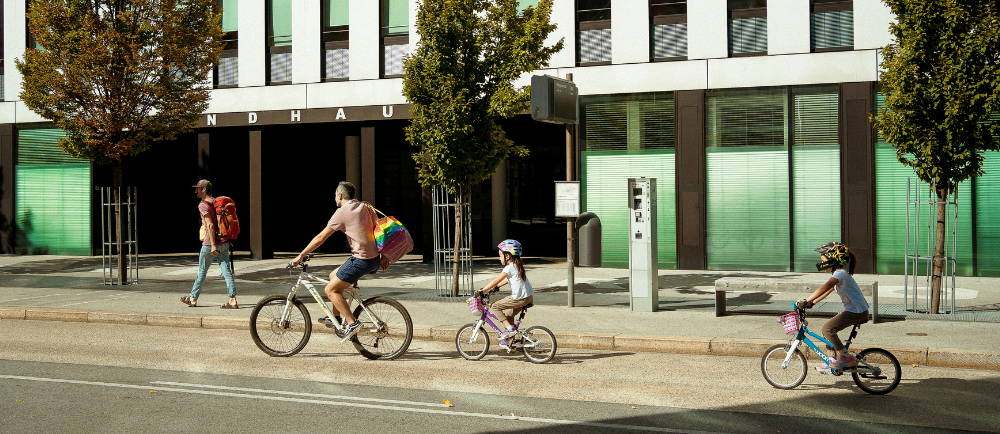 A family riding bikes and electric bikes in a city
