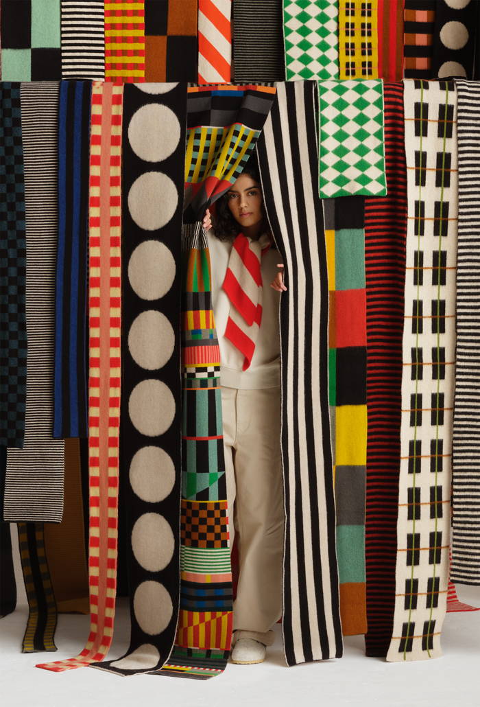 model peers out from behind a wall of colourful Jo Gordon scarves